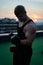 Caucasian white muscular man lifting dumbbells against the sunset sky background. Concept of willpower, motivation and