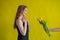 Caucasian woman accepts tulips as a gift on yellow background.