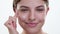 Caucasian Woman Applying Face Cream on White Background