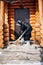 Caucasian woman cleans snow. Elderly woman in down jacket and felt boots sweeps snow from porch with broom on background