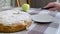 caucasian woman cut triangular slice of classic apple pie and serving on white plate