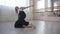 Caucasian woman dancing contemporary on the floor in a ballet class.