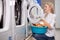 Caucasian woman doing the daily chores - laundry. Female folded clean clothes in the laundry basin