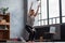 Caucasian woman doing Utkatasana, Chair Pose using block at home