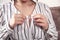 Caucasian woman fastening buttons on shirt at home