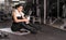 caucasian woman in the gym after a workout relaxed resting sitting on a karemat holding a bottle of water in her hands