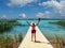 Caucasian woman - happy cyclist - standing on a landing stage at lake.