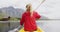 Caucasian woman having a good time on a trip to the mountains, kayaking on a lake, holding a paddle,