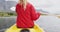 Caucasian woman having a good time on a trip to the mountains, kayaking on a lake, holding a paddle