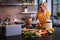 Caucasian woman and her daughter spending time in the kitchen and using a laptop