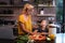 Caucasian woman and her daughter spending time in the kitchen and using a laptop