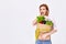 caucasian woman hold paper bag with vegetables
