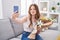 Caucasian woman holding bouquet of white flowers taking a selfie picture smiling looking to the side and staring away thinking