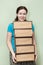 Caucasian woman holding several cardboard boxes in hands, removal into house