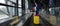 Caucasian woman on a horizontal escalator with a suitcase at the airport. A girl with pink luggage rides on a moving