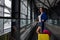 Caucasian woman on a horizontal escalator with a suitcase at the airport. A girl with pink luggage rides on a moving