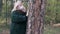 Caucasian woman hugs a tree in the park in a mask to protect against coronavirus. A woman takes off her mask and enjoys the fresh