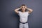 Caucasian woman in neutral casual outfit standing on a neutral grey background. Portrait with emotions: angry, pain, sickness and