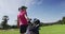 Caucasian woman playing golf carrying bag filled with golf clubs