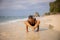 Caucasian woman practicing Bhujapidasana, Arm Pressure Balance on the beach. Strong healthy body. Self-care concept. Yoga retreat