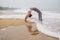 Caucasian woman practicing yoga at seashore of tropic ocean