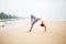 Caucasian woman practicing yoga at seashore of tropic ocean