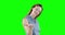 Caucasian woman raising hand on green background