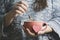 Caucasian woman`s hands holding a mug with some hot drink beverage with a paper heart shape. Social media relax