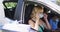 Caucasian woman sitting in car, wearing face mask, having covid test done by medical worker outdoors