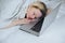 Caucasian woman is sleeping on her laptop keyboard after watching some TV series