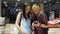 A Caucasian woman is standing with a cute teenage daughter at a shop window in the aisle of a shopping center and