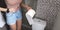 Caucasian woman standing in toilet holding toilet paper