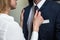 Caucasian woman straightens businessman`s collar. Passionate flirting business people. Love affair in office. Close up
