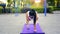 Caucasian woman train her biceps muscles with dumbbells on a purple karemat at warm sunny day