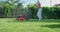 Caucasian woman using lawn mower on backyard