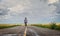 Caucasian woman walking in the middle of the highway