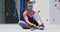 Caucasian woman wearing face mask putting on climbing shoes at indoor climbing wall