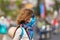 Caucasian woman wearing sanitary mask outdoors in Da Lat city centre Vietnam. Tourist with medical mask protection against risk of