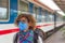 Caucasian woman wearing sanitary mask while traveling by train in Vietnam. Tourist with medical mask protection against risk of