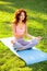 Caucasian woman wearing sport clothes meditating in the garden