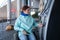 Caucasian woman in a wheelchair buys a ticket at a self-service ticket office.