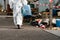 Caucasian woman workers wearing PPE protective clothing and gas masks, goggles, holding old petrol tanks