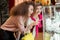 Caucasian women, standing in front of window display, looking at golden jewelry