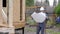 Caucasian worker in front of a house. Architects or builder check plans in a half built timber frame house. Builder on a