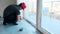 Caucasian worker lay polyethylene film on floor.