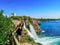 Caucasian young adult female tourist on the background of Duden Waterfall and an airplane in the sky Antalya, Turkey. The