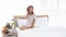 Caucasian young and beautiful happy woman sitting on the comfortable double bed in the modern or minimal