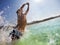 Caucasian young boy jumping in water, playing and having fun