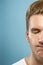 Caucasian young man`s close up portrait on blue background