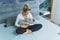 Caucasian young mother with blond hair sitting in bedroom looking at her newborn baby son wrapped in soft blue blanket